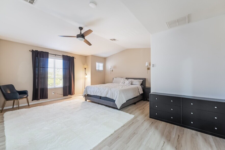 Bedroom with light wood-type flooring, ceiling fan, and vaulted ceiling - 1179 Antoinette St