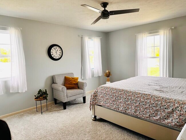 A master suite featuring a walk-in closet, fresh paint, new carpeting, and three windows. - 4555 Cider Wood Dr NW