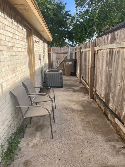 Back patio with chairs, garbage can, gate, and outdoor tools - 2607 Ringold Cir