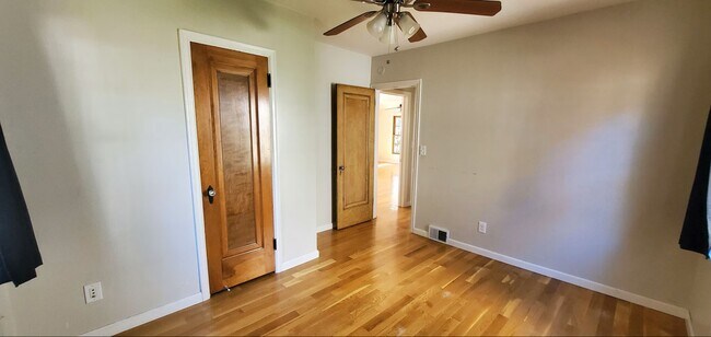 Primary bedroom with hardwood floors and generous space for a full bedroom setup. - 2923 Arthur St NE