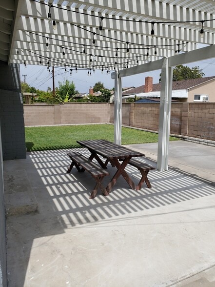 backyard with trellis patio, grass and flowerbeds - 8608 Harrison Way