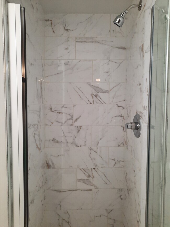 Calacutta gold ceramic tile shower surround in en-suite bathroom. - 434 Clinton Pl
