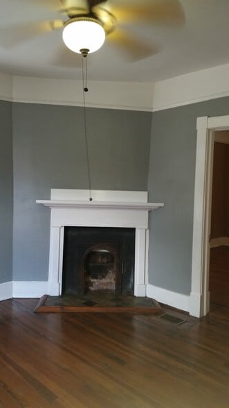 Front Bedroom - Original hardwood floors, decorative fireplace, & ceiling fan with light. - 1215 Java Pl