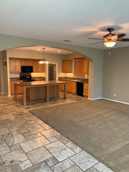 Living Room (foreground.) Kitchen (background.) Pantry with spacious shelving. - 84126 Canzone Dr