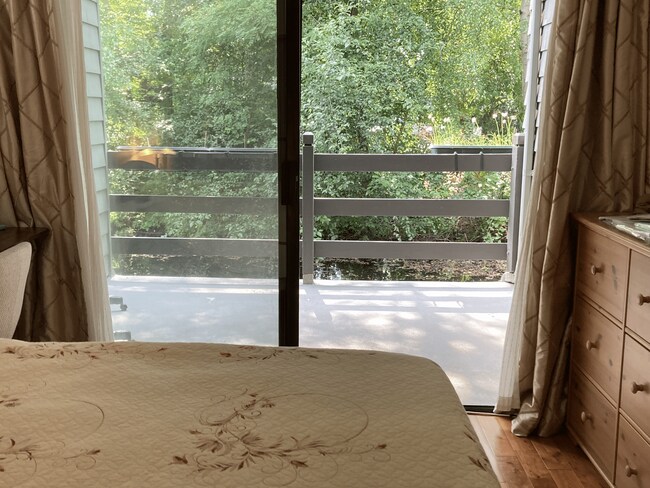 Looking out at the deck through sliding doors from one of the bedrooms. - 6 Lake Bellevue Dr