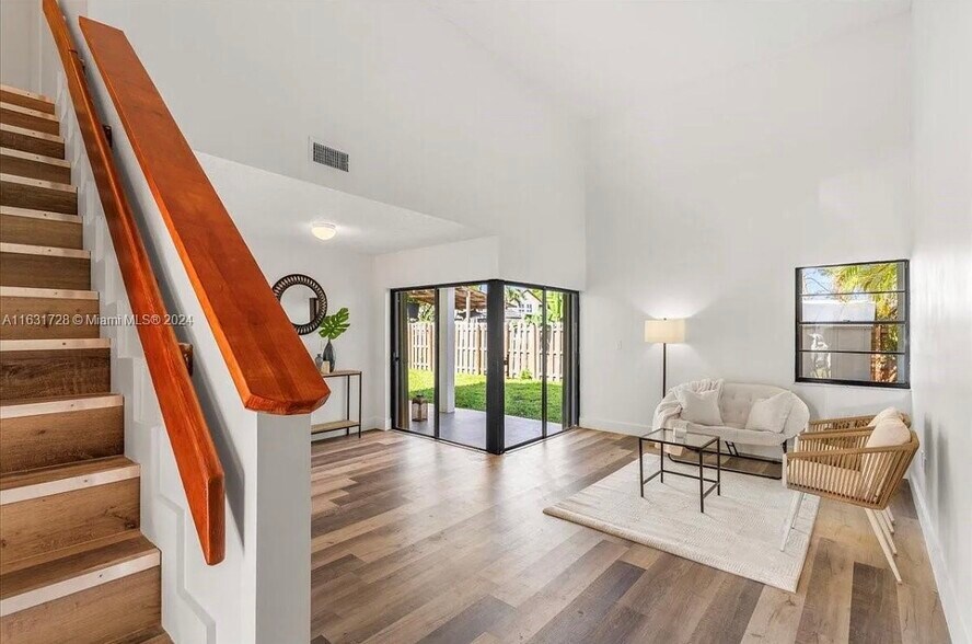 Shared living room space with vaulted ceilings and access to patio - 2512 SW 113th Ct