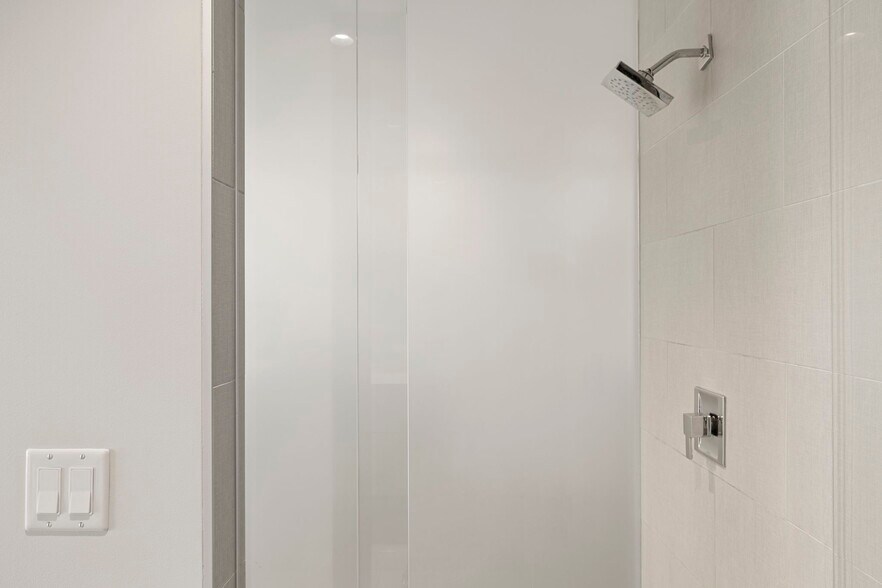 Step-in shower with with rain shower head, tile surround, and glass enclosure - 4422 N 75th St