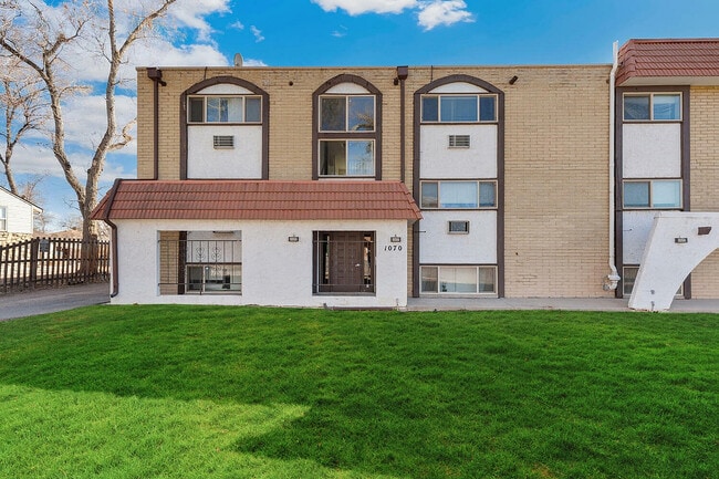Charming apartment exterior with modern architecture, featuring red-tiled roof and lush green lawn. - Country Club