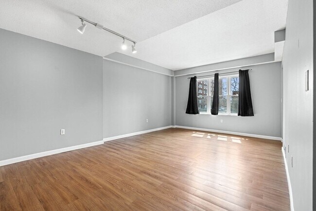 Building Photo - Updated 1BR Condo with Balcony, Garage Parking & Storage Near Commuter Rail