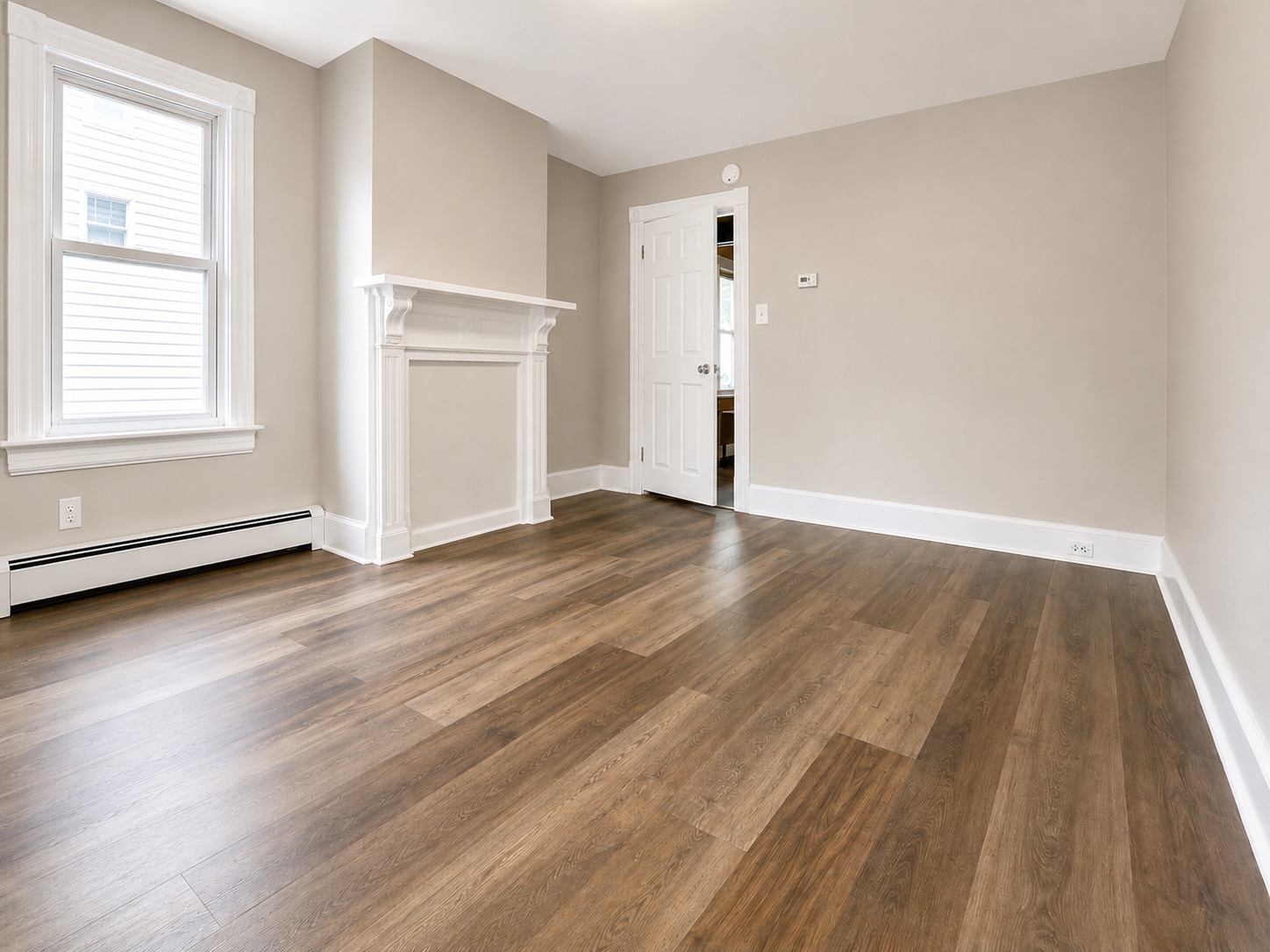Bright living room with new luxury vinyl plank flooring, fresh neutral paint, decorative mantel - 78 Orchard St
