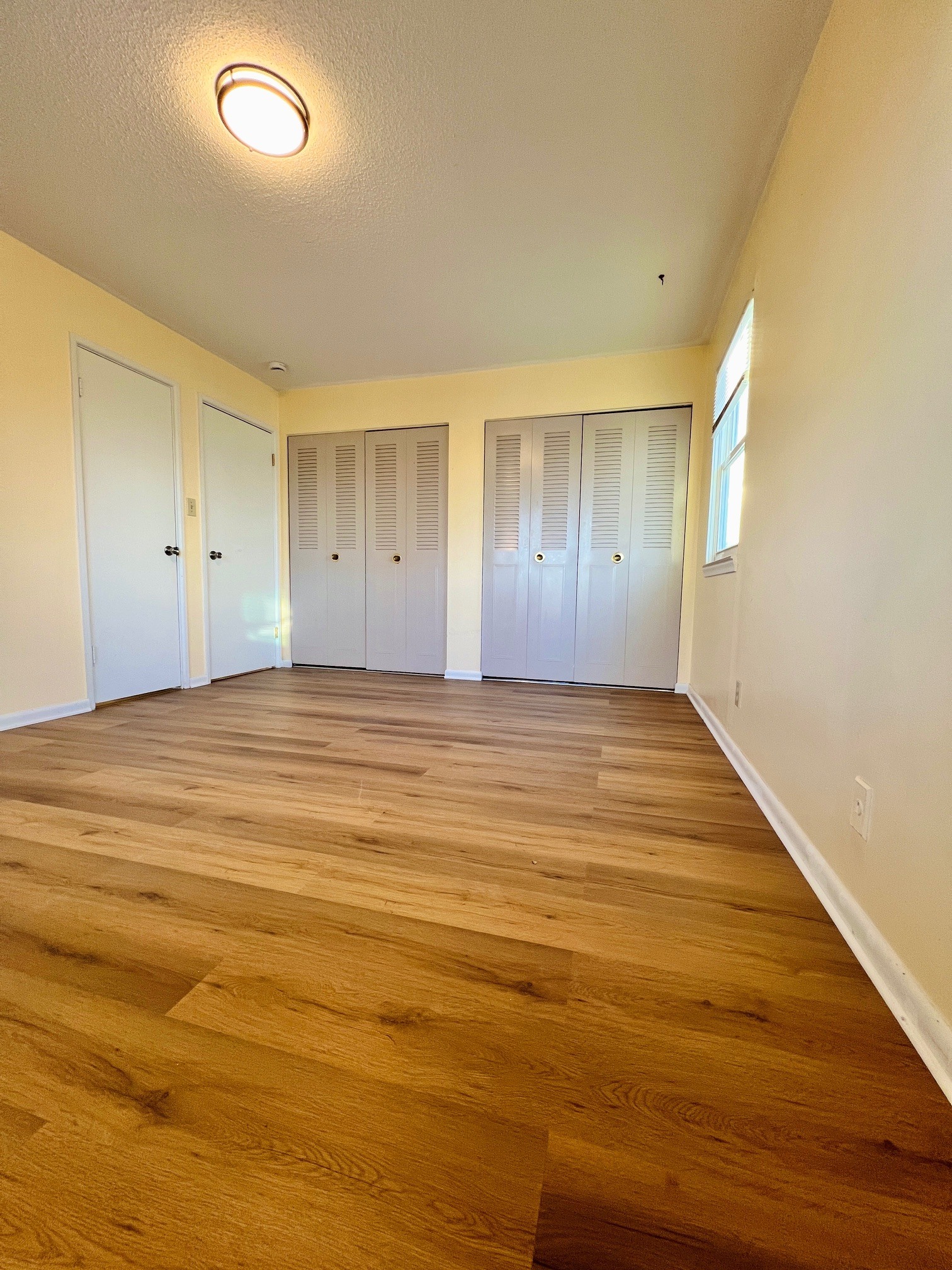Bedroom with new luxury vinyl plank flooring and spacious closets - 9315 Bluejacket St