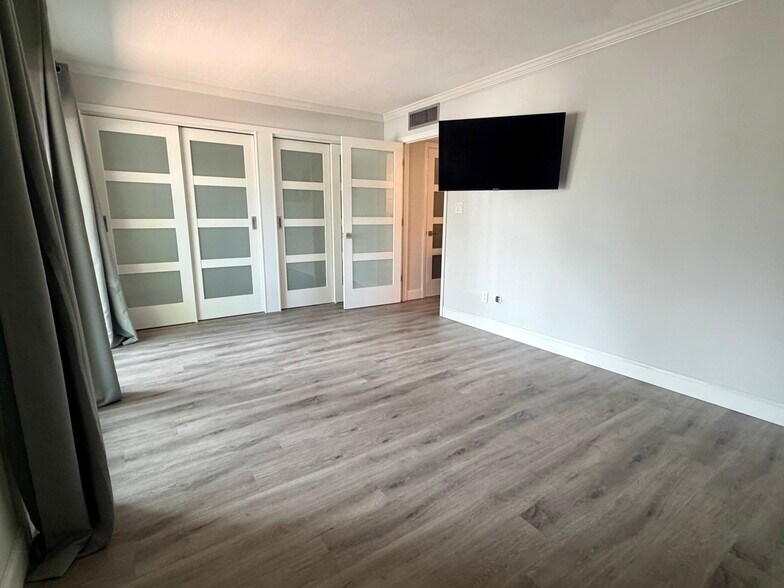 Primary bedroom closets and mounted TV - 105 4th Ave NE