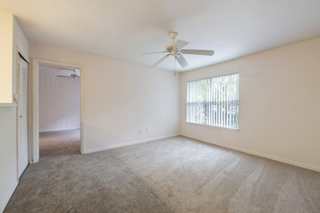 Bedroom with carpet flooring and large window for natural lighting - Park Villas Apartments