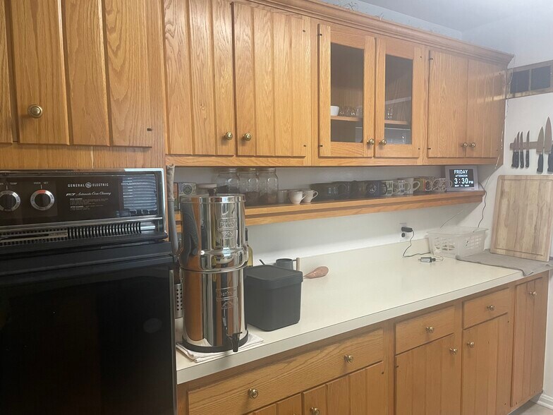 Kitchen has wood cabinets, tile floor, wall oven, cooktop, microwave, dishwasher and refrigerator. - 9707 Bristol Ave
