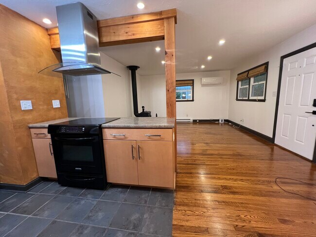 View of kitchen peninsula, with living space and stainless steel vent hood. - 73 Swannanoa Ave