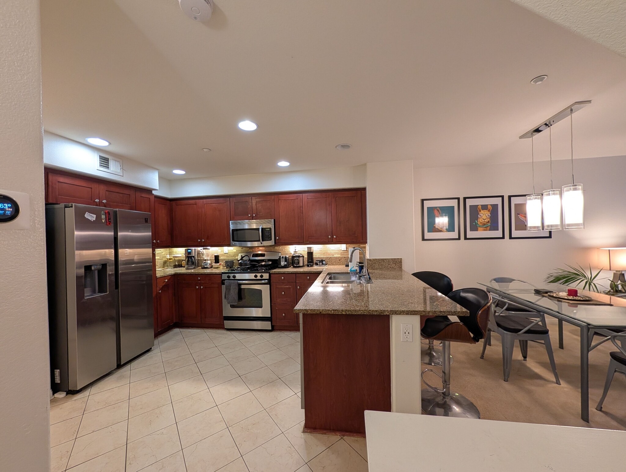 View of kitchen area, kitchen counter seating area with 2 bar stools next to dining area. - 3542 Shoreline Bluff Lane