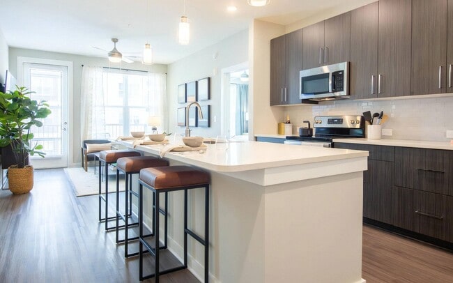 A kitchen island seating three, with room left over to prep and plate. - The Elden Galleria