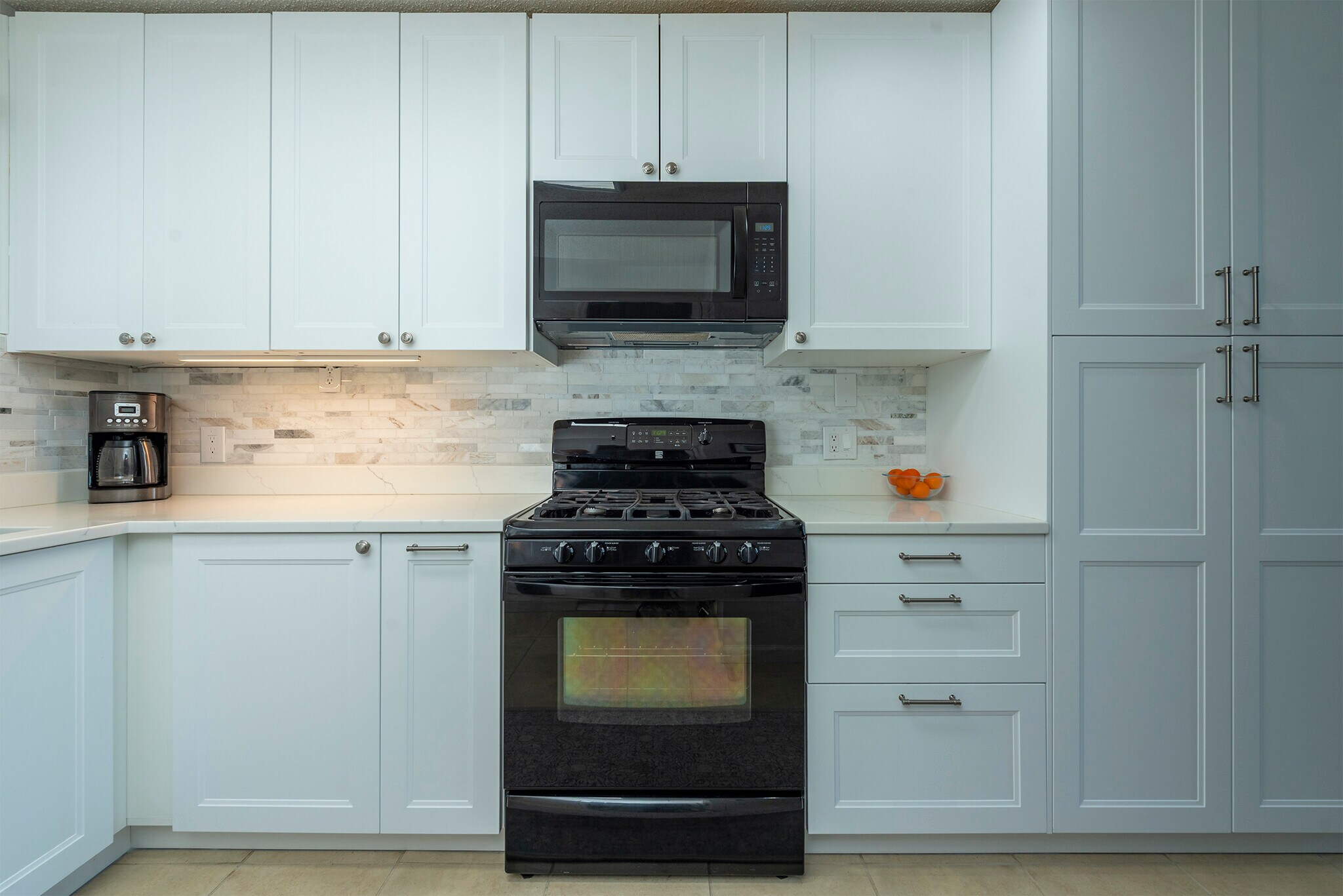 Gas range cooking with ample cabinet storage and elegant quartz countertops. - 405 Windswept Dr