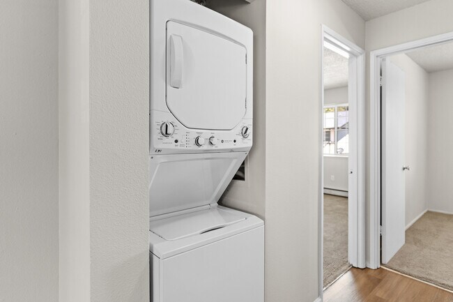 Enjoy the convenience of an in-home laundry setup, seamlessly integrated into the hallway. - University Crossing Apartments