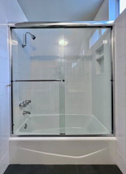 Glass-enclosed tub/shower with new tile and fixtures. - 11639 Chenault St