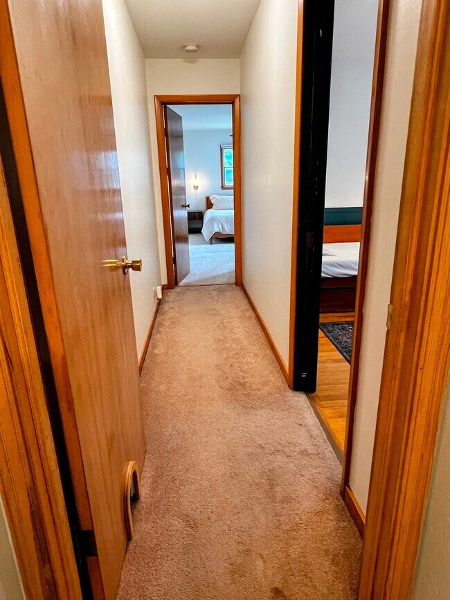 From the bathroom, a hallway leads to the three bedrooms. - 228 W Lexington Blvd