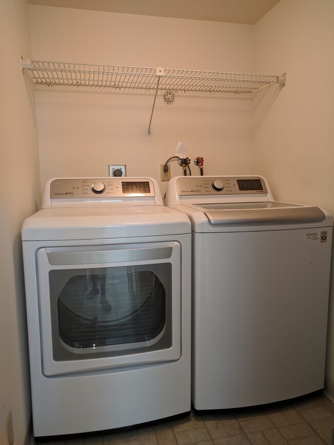 Laundry room with new digital washer & dryer, convenient shelf space, and new hot water heater. - 198 NW 67th St