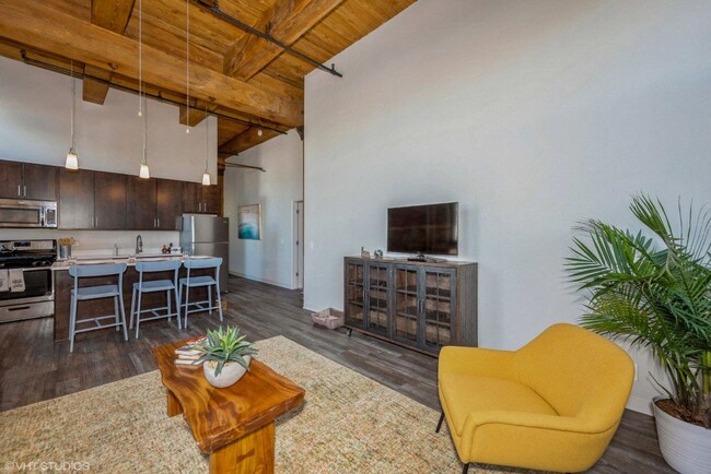 Open concept layout with gorgeous updated flooring and vaulted ceilings - Carriage House Lofts