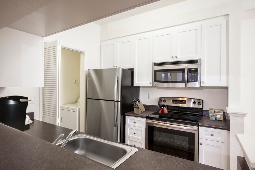 Classic Package I kitchen with stainless steel appliances, white cabinetry, laminate countertops, and hard surface flooring - eaves Dublin