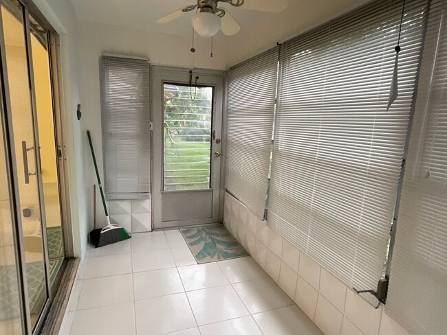 Sunroom with exit leading to building grill and patio area - 2900 NW 47th Terrace