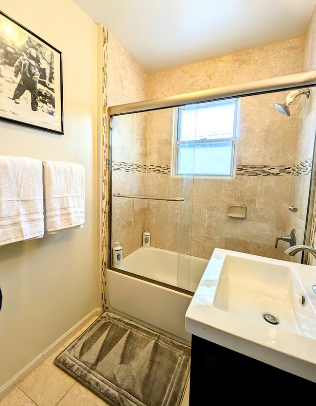 Tiled, Full tub and shower bathroom. Basic amenities for you to enjoy. - 3123 W 55th Ave