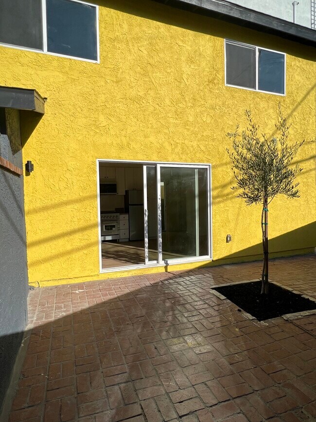 patio from kitchen living with a olive tree and lava rocks - 11120 Hartsook St