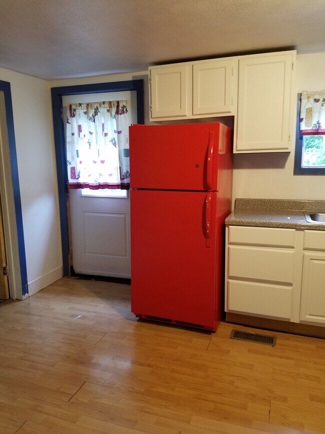 Kitchen, west wall with top-freezer refrigerator and rear entry door. - 15 Goodrich St