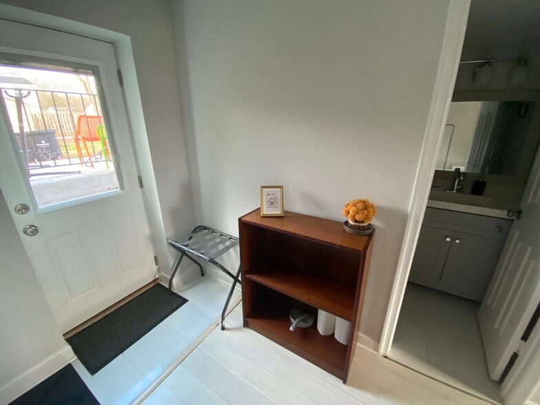 Small bookshelf and view of the private entrance from the backyard. - 7922 Fitzroy St