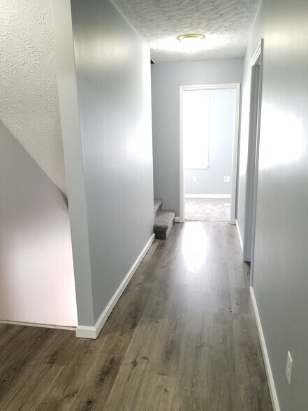 Hallway going from master to 2nd bath and bedroom with new paint and laminate flooring. - 343 Beaverview Dr