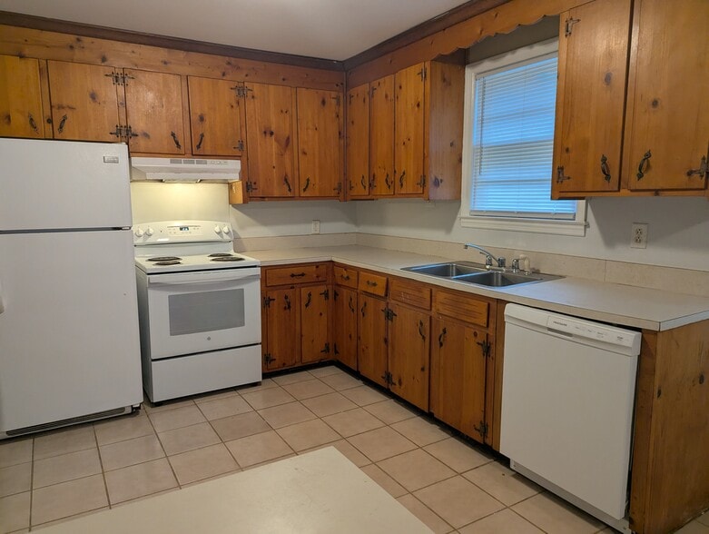 Kitchen featuring classic wood cabinetry, white electric range, and a window above the sink. - 1527 Brookbank Ave