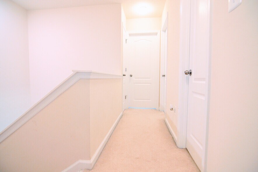 Third floor hallway (2 bedrooms at end of hall; full bath behind middle hall door) - 11696 Palm Desert Pl