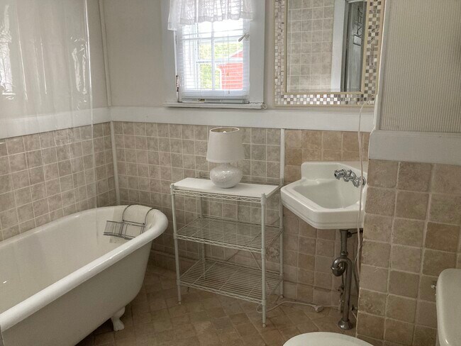 Bathroom with old-fashioned soaker tub with shower and view of the marina - 317 Eagle St
