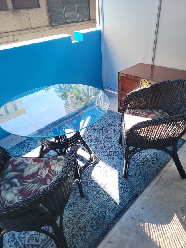 Glass topped dining table on lanai - 441 Lewers St