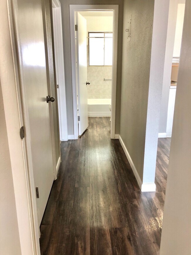Experience the elegance of this bright and spacious hallway, featuring modern wood flooring. - GRACE LANDINGS APARTMENTS