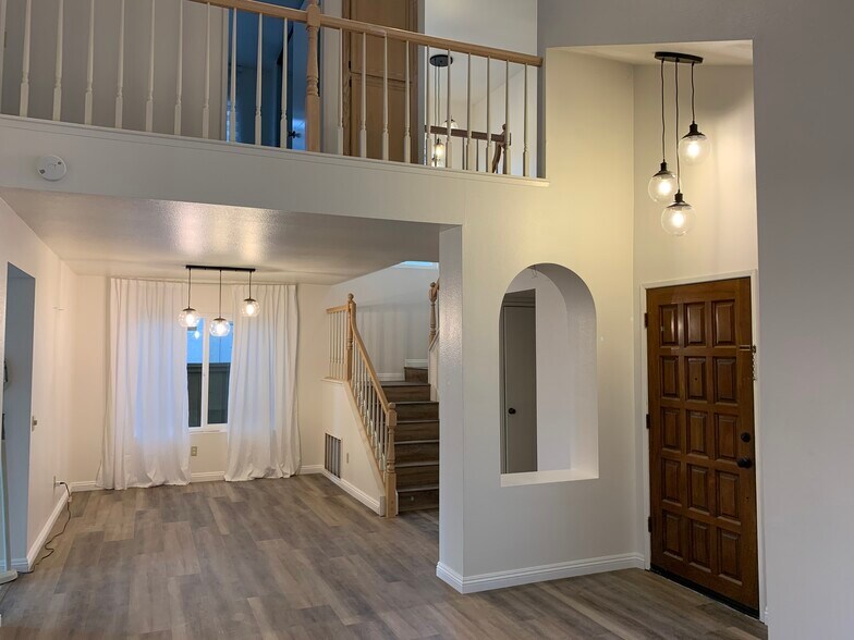 Living room looking at donning area and stairs to 2nd floor - 10734 Chinon Cir