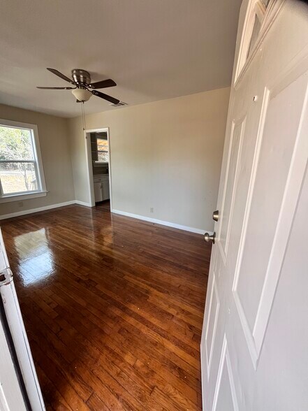 Living room with natural light and riginal hardwood floors stained and finished - 1565 Pump Station Rd