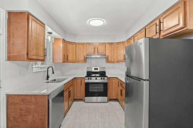 Step into a modern kitchen boasting sleek appliances and ample storage. - 5580 West 4th Avenue Townhomes