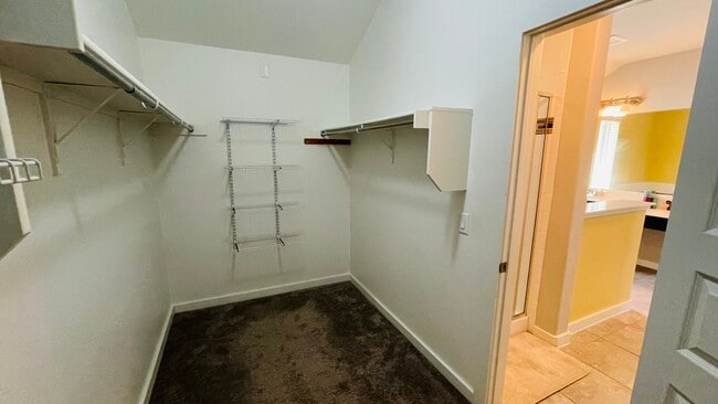Walk-in closet through master bath with 4 walls of shelving - 7108 Garnet Mill Ln