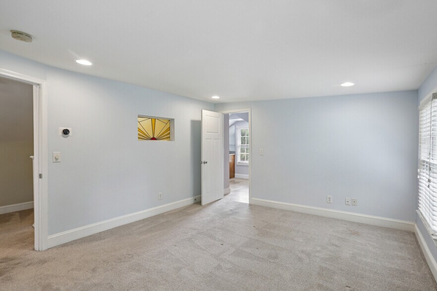 Large primary bedroom upstairs. Stain glassed window, original to home. - 781 Rosedale Ave SE