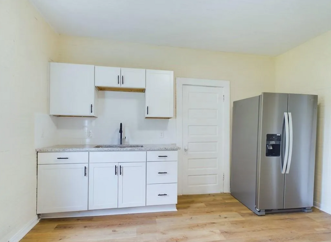 Kitchen: Stainless steel appliances, including a refrigerator, add a modern touch - 1011 Elm St