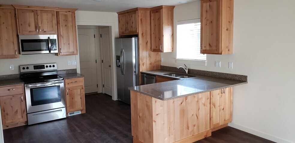 Beautiful kitchen with knotty alder cabinets, granite countertops, large closet pantry, garbage disposal, and stainless steel appliances - 1121 Sundial Ln