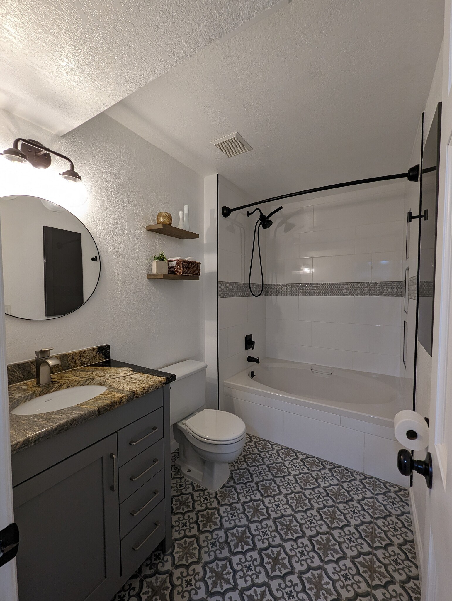 Beautifully renovated restroom with a handheld shower head and built-in shower shelves. - 842 S Vance St