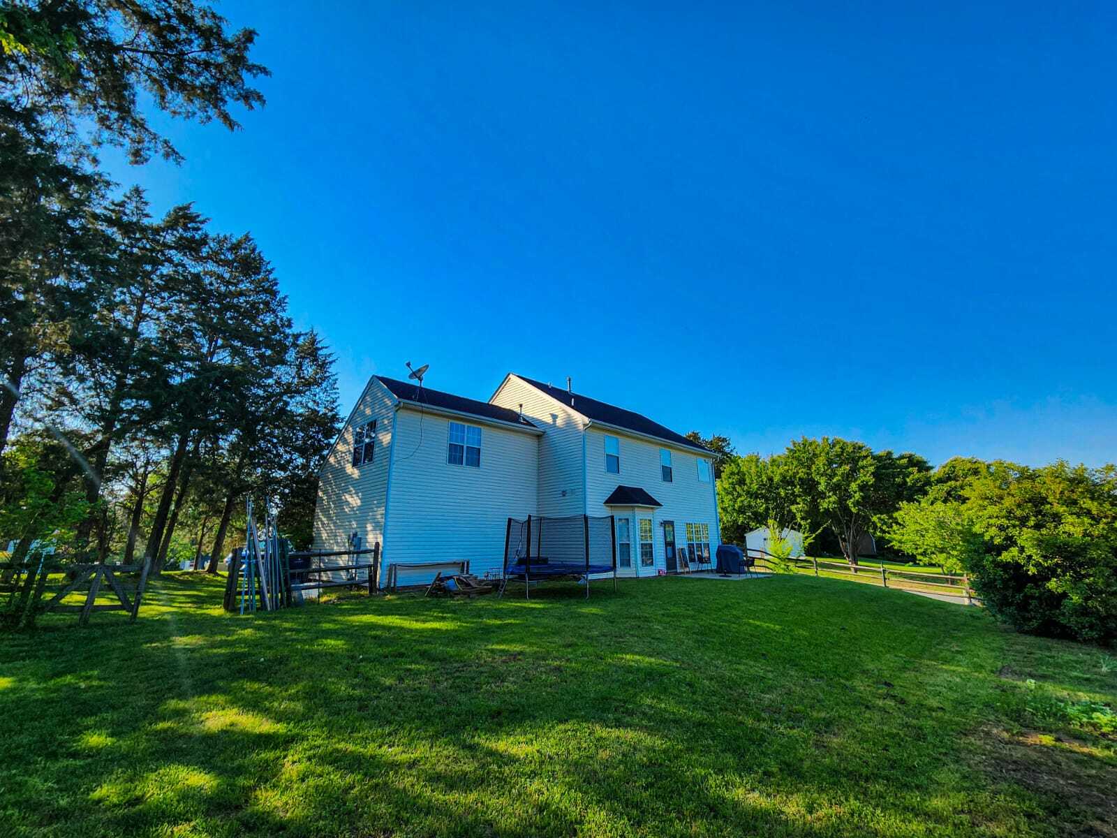 Rear view showing large yard, trees, and space for outdoor fun. - 7801 Peach Blossom Ct