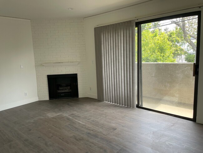 Opposite view of living room with gas fireplace & sliding door to balcony - 10330 Riverside Dr