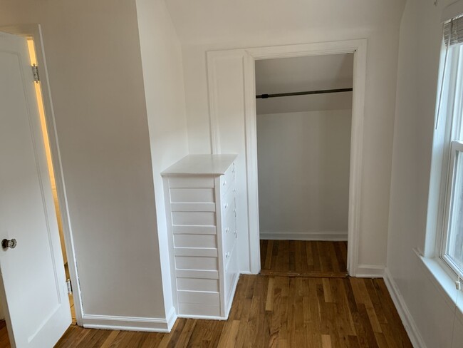 Bedroom closet with closet space beyond opening on both sides. - 1910 Evans Ave